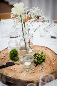 A charming rustic table centerpiece featuring flowers in glass jars on a wooden slab.