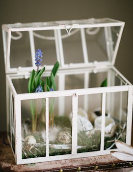A charming terrarium featuring spring flowers and decorative eggs in a rustic setting.